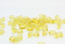 Omega-3 vis krill algen capsules naast verse vis op tafel